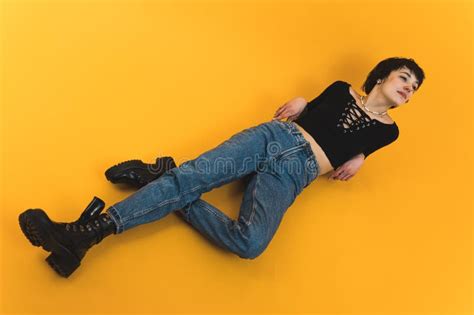 Female Model Laying On The Floor In A Black Laced Top And Jeans High Angle Shot Stock Image