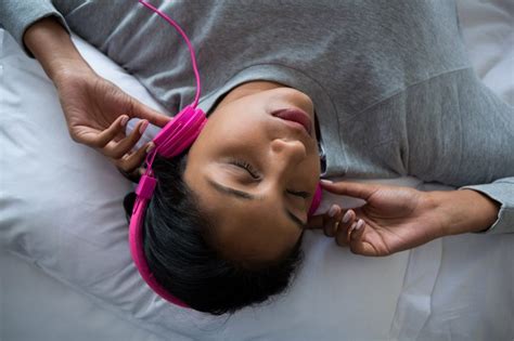 Woman Listening To Music While Sleeping On Bed International Institute Of Sleep