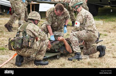 Medics Givving Assistance To Wounded Soldier On Stretcher During Stock