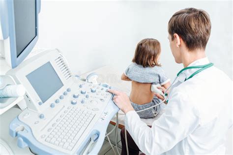 Young Doctor Performing Kidney Ultrasound Scan On A Ten Year Old Girl