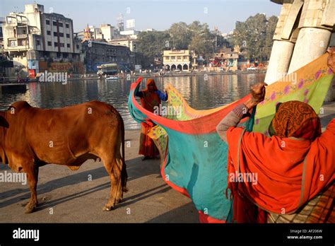 Indian Women Stand Holding Sari To Dry In Sunshine At Ramkund Bathing Tank Nasik Maharashtra