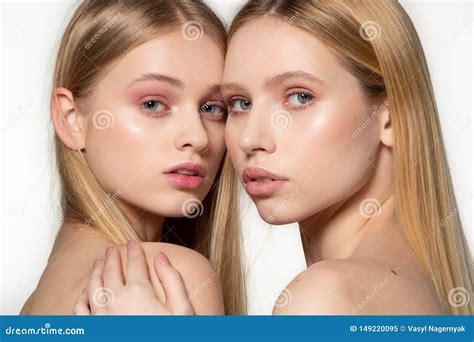 Two Attractive Twins Woman With Blonde Long Hair Posing In Glamour Makeup Standin Behind Each