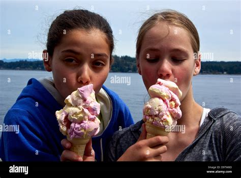 Two Pretty Young Girls Tasting Each Others Huge Ice Cream Cones