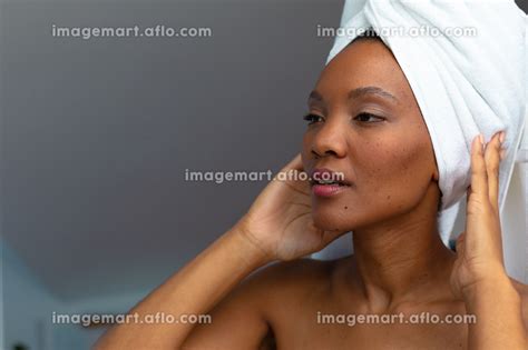 Young African American Woman Looking Away While Adjusting Her Head Towel In Bathroom Copy Space