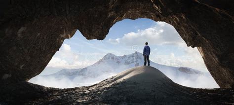 Adult Hiker Male Standing Inside A Rocky Mountain Cave Overlooking The