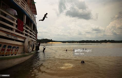 an indigenous tribe member leaps off a riverboat as others swim in news photo getty images
