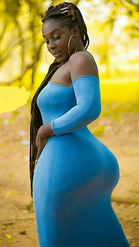 A Pregnant Woman In A Blue Dress Poses For The Camera With Her Hands On Her Hips