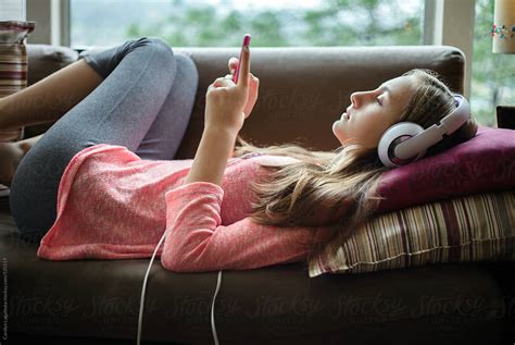 Teenage Girl Relaxing And Listening To Music At Home By Stocksy