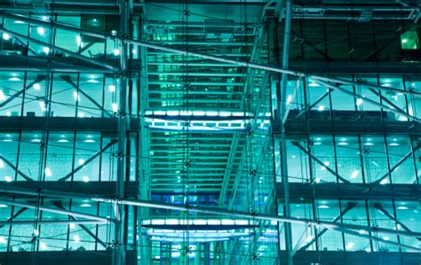 Illuminated Glass Facade Of A Futuristic Office Building At Night Stock