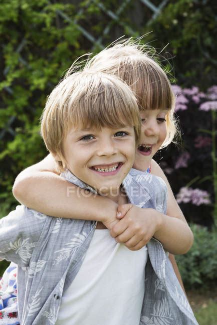 Girl Hugging A Smiling Boy — Carrying Eye Contact Stock Photo