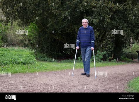 Senior Man Walking With Crutches Stock Photo Alamy