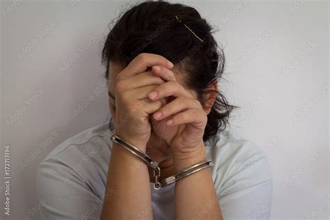 Desperate Criminal Woman Sitting On The Floor In Handcuffs Foto De