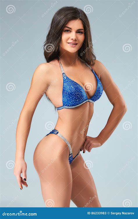 Sexy Donkerbruine Bodybuildervrouw In Blauwe Bikini Stock Afbeelding