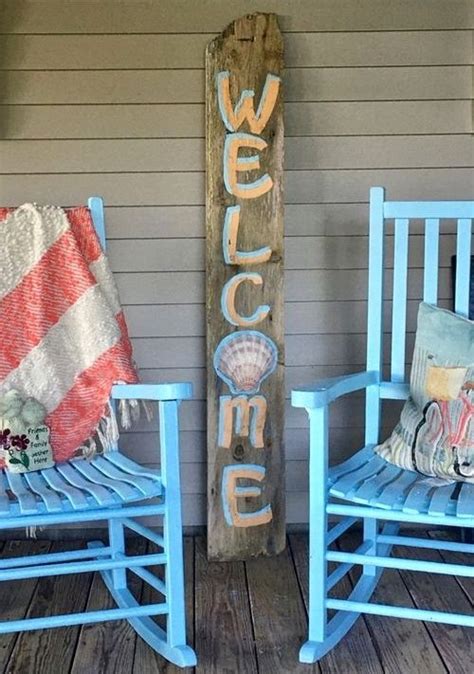 Two Rocking Chairs And A Welcome Sign On A Porch With Blue Painted Wood