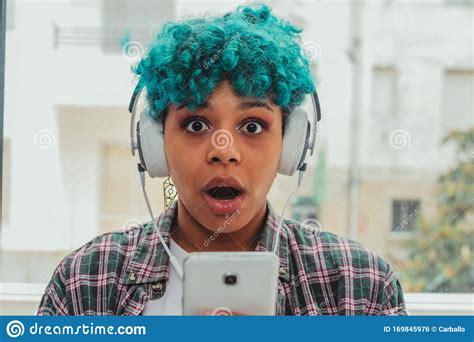 Girl Or Young Woman With Blue Hair Looking At Mobile Phone Stock Photo
