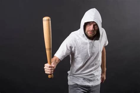 Bearded Man With Baseball Bat Sit In Armchair Criminal Wear Hood In Coat Gangster Guy Strike