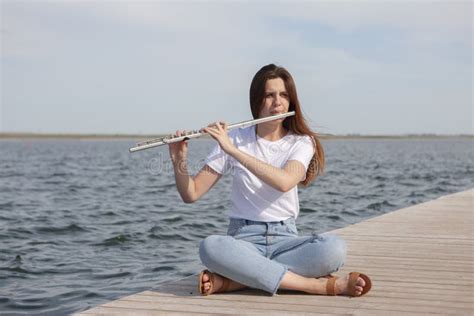A Beautiful Woman Posing In Beach While Playing On A Flute Stock Image Image Of Classic