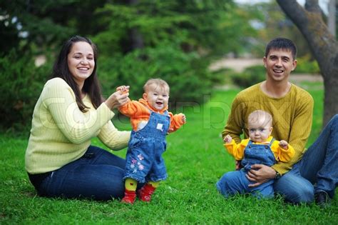 Check spelling or type a new query. Portrait of happy young parents with their two babies twins having fun in park | Stock Photo ...