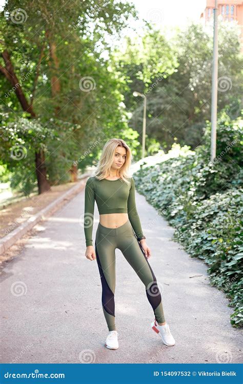 Young Slim Woman With A Sporty Body Long Blond Hair Dressed In A Sports Top And Leggings