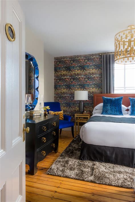 Eclectic Bedroom With Royal Blue Accents And Feather Design Accent Wall