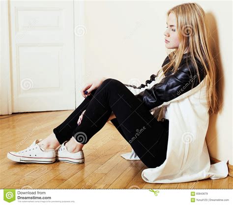Young Pretty Teenage Blond Girl Sitting On Floor At Home