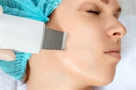 A Gloved Beautician Cleanses The Skin On The Face Using A Special Gel