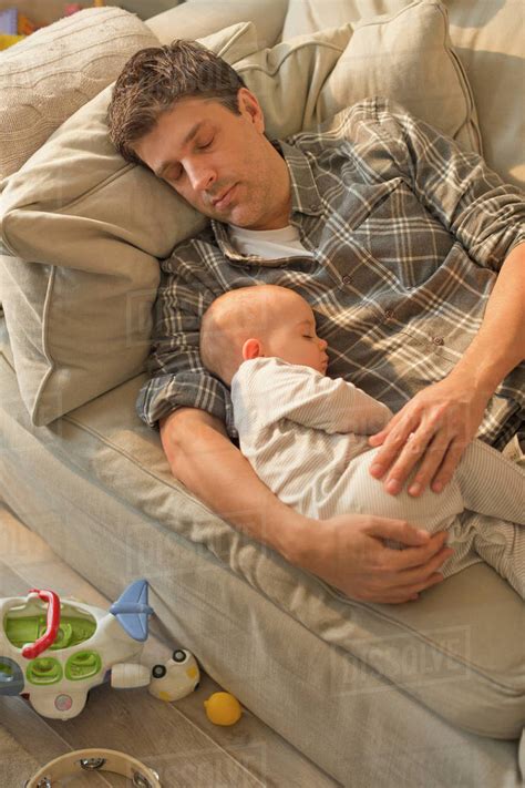 Exhausted Father And Baby Son Sleeping On Sofa Stock Photo Dissolve
