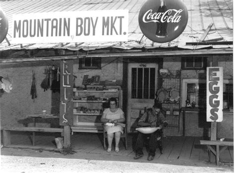 Two People Sitting On A Bench In Front Of A Store
