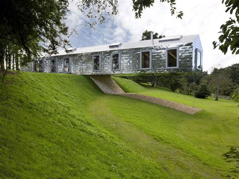 Clad in elegant reflective steel tiles, the house dramatically cantilevers over the landscape. The Balancing Barn - Suffolk | Cool Places