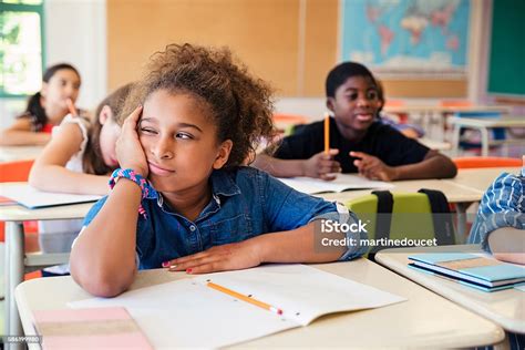 Bored Little Girl In Elementary Classroom Stock Photo Download Image