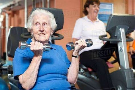 Older Woman Lifting Weights In Gym Stock Photo Dissolve