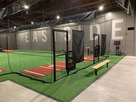 An Indoor Batting Cage In The Middle Of A Baseball Field