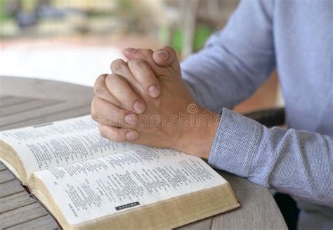 Rezando As Mãos Na Bíblia Aberta Foto De Stock Imagem De Velho