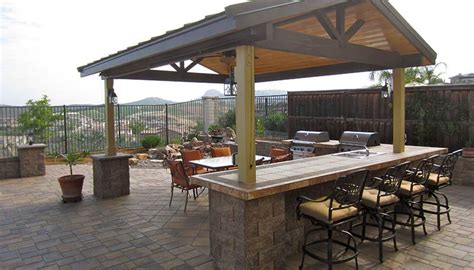 Outdoor kitchens continue to gain in popularity as homeowners across the county seek to spend more time outdoors. pavers, bar stools, pergola roof, Outdoor Kitchen/Bar ...