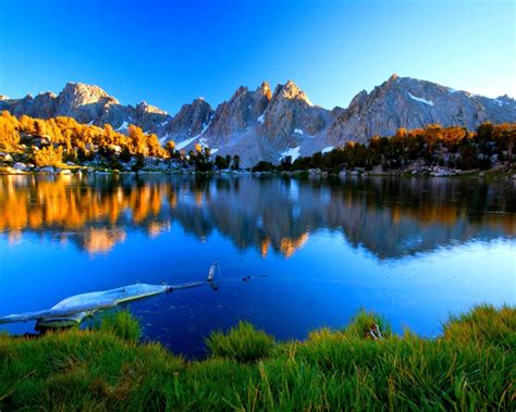 Summer Mountain Lake Shore With Green Grass Pine Trees Mountains Rocky