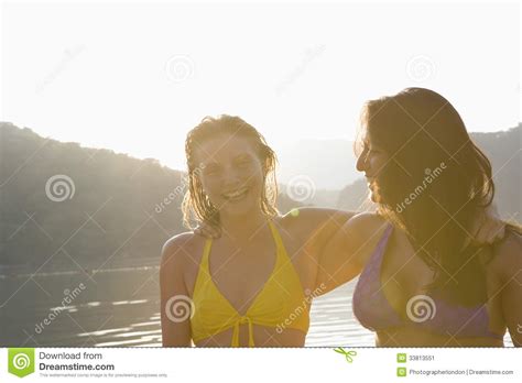 Nette Freunde in Den Bikinis Gegen See Stockbild Bild von dämmerung kaukasisch