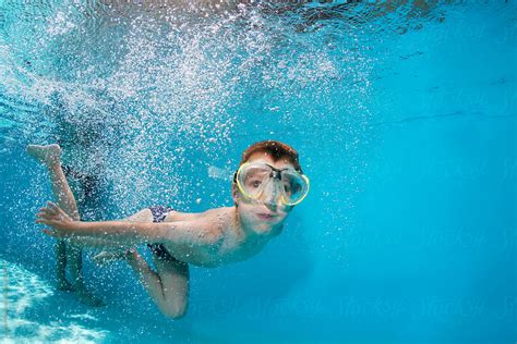 Young Boy Diving In The Swimming Pool By Stocksy Contributor Jovana