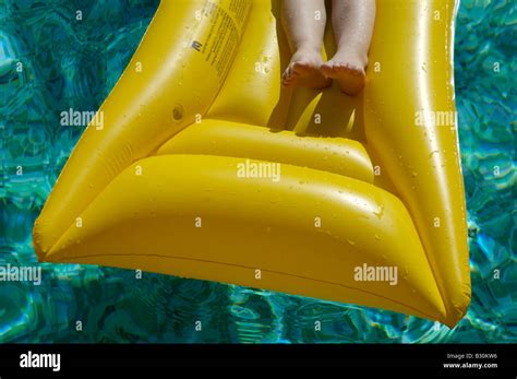 A Young Boy Having Fun On A Lilo In A Swimming Pool Stock Photo Alamy