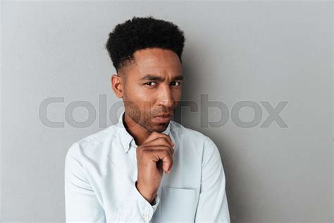 Young Pensive African Man Looking Closely At Camera Stock Image
