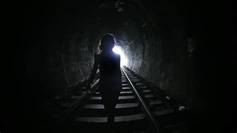 Silhouette Of Woman Walking Through Dark Railway Tunnel Conceptual Slow