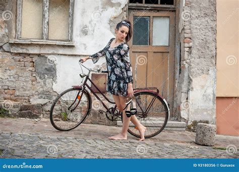 jeune fille sexy de brune avec la vieille rétro bicyclette de vintage de style photo stock