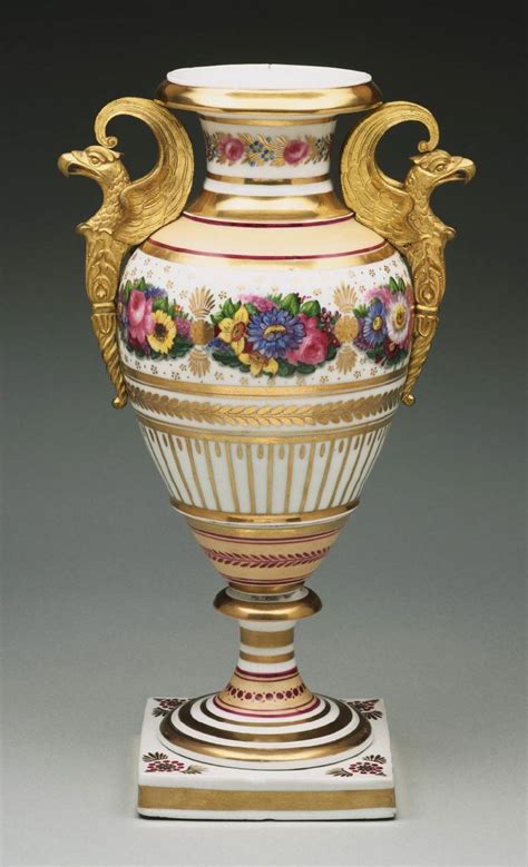 An Ornate Vase With Gold Trimming And Painted Flowers On It S Sides