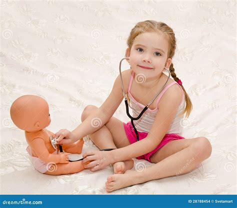 Маленькая девочка играя с куклой в больнице Стоковое Фото изображение насчитывающей детство