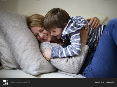 Mother And Son Cuddling On The Couch Stock Photo Offset