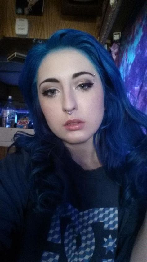A Woman With Blue Hair Is Taking A Selfie