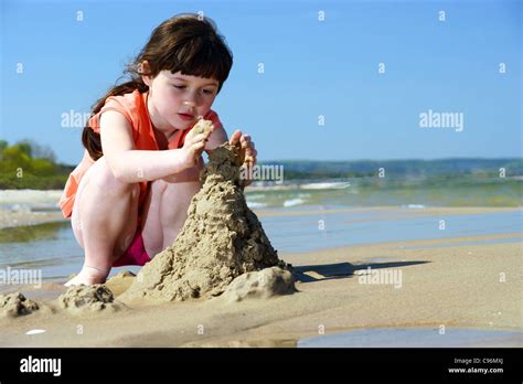 Kids On The Beach Young Girl Playing In The Sand To Make Stock Photo