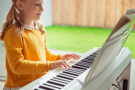 Portrait Of Pretty Little Girl Having Piano Lesson At Modern White E