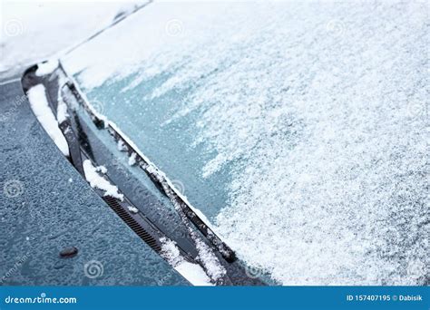 Close Up Of Car Windshield And Wipers Covered With Ice And Snow On