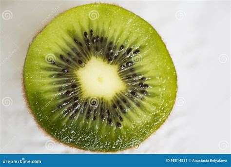 Corte El Kiwi Verde De La Fruta Con Las Semillas Negras Y La Base