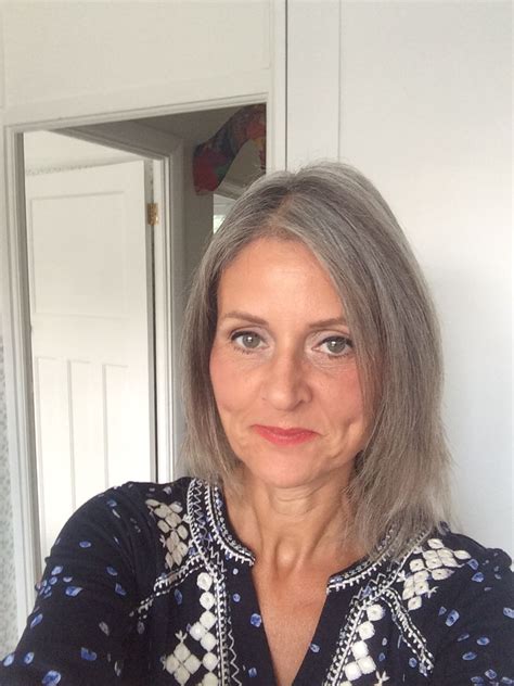 A Woman With Grey Hair Is Taking A Selfie